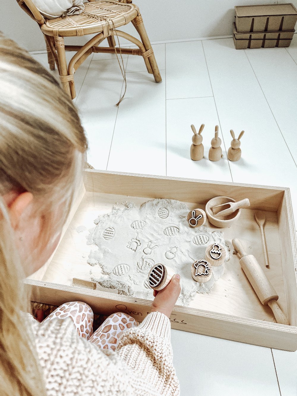 Houten paas stempels - yourlittlefamily-nl - Vier verschillende paasstempels in het kinetische zand in een speelbak met deegroller, schepje en lepel. 